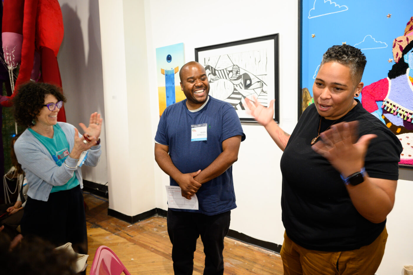 three people smiling at a gathering 