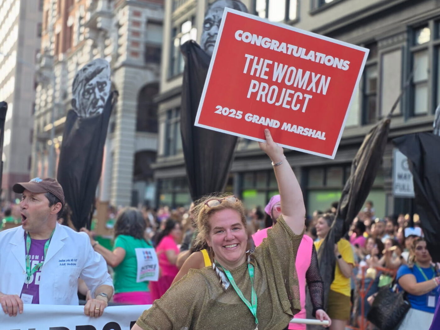 Jocelyn holding a sign that says "congratulations the womxn project"