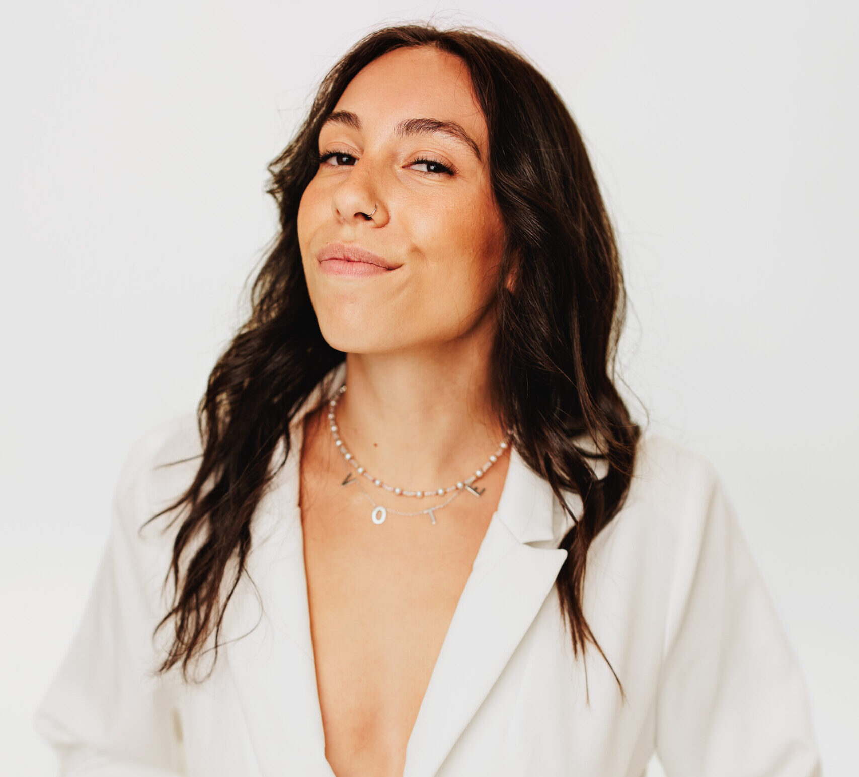 Sophia smiling wearing a white blazer 