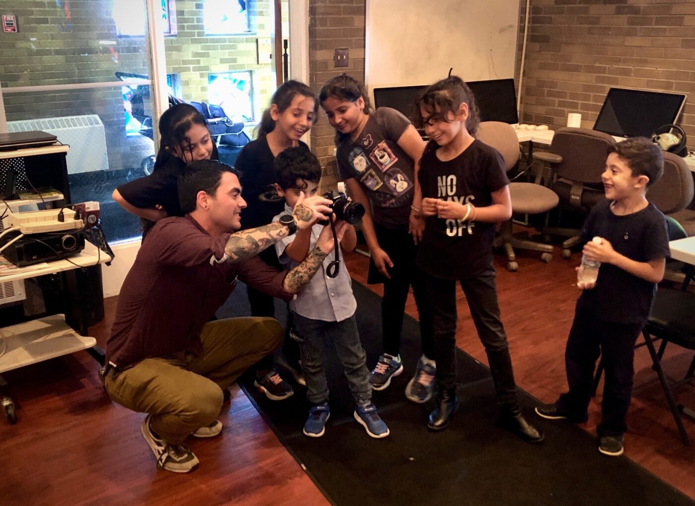 Patrick showing a class of Syrian youth how to use the camera to capture photos. Photo by Ethan Hayden
