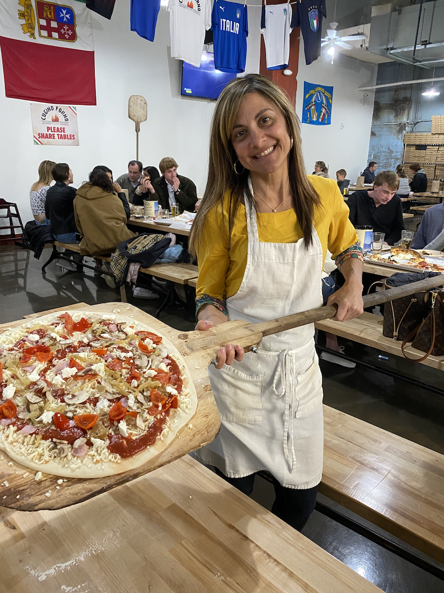 Angela Levine holding a pizza she made 